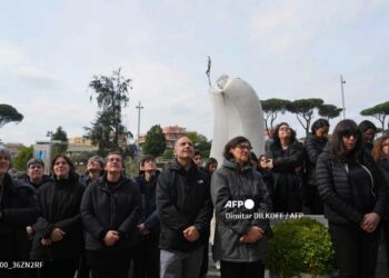 Varias personas oran por el Papa