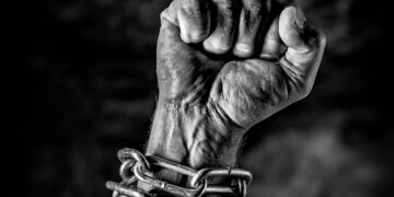 Arm in chains and the hand is closed as a fist, struggle free from oppression and tyranny ,