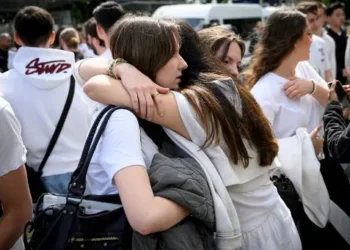 Los compañeros de la fallecida colocaron flores en la puerta de su colegio