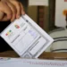 Una persona emitiendo su voto.