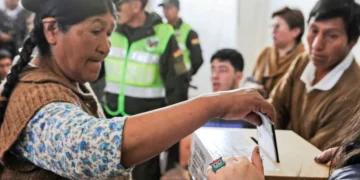 Una persona emite su voto en la primera vuelta electoral con respaldo policial. Foto: Archivo.
