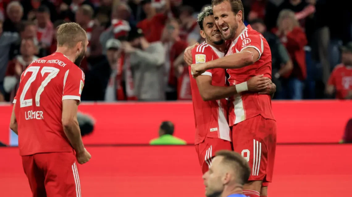 Harry Kane (derecha) celebra un gol junto a su compañero colombiano Luis Díaz (centro) en el partido de la Bundesliga ante el Leipzig. (FOTO: AFP)
