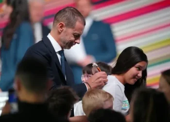 El presidente de la UEFA, Aleksander Ceferin, le firma una camiseta a una niña durante el Congreso Ordinario del organismo. (FOTO: AFP)