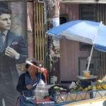 Juguito (foto r atahuichi) Vendedora prepara jugo de naranja yungueña en un puesto callejero bajo una sombrilla azul en La Paz.